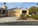 Beige single-story house with desert landscaping and a two-car garage at 332 Wild Plum Ln, Las Vegas, NV 89107