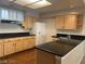 Bright kitchen with wood cabinets, dark countertops, and stainless steel appliances at 332 Wild Plum Ln, Las Vegas, NV 89107