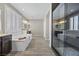 Bright bathroom features a soaking tub with wood-look tile and plantation shutters at 3428 Royal Calloway Ave, Las Vegas, NV 89141