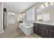 Elegant bathroom with a tub, dual sinks, and shuttered windows at 3428 Royal Calloway Ave, Las Vegas, NV 89141