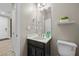 Well-lit powder room featuring a modern vanity and toilet at 3428 Royal Calloway Ave, Las Vegas, NV 89141