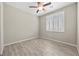 Inviting bedroom featuring wood-look tile flooring, a ceiling fan, and bright window, creating a serene and comfortable space at 3428 Royal Calloway Ave, Las Vegas, NV 89141