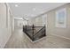 Bright upstairs hallway with wood-style tile flooring, recessed lighting, and white trim at 3428 Royal Calloway Ave, Las Vegas, NV 89141