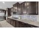 Modern kitchen featuring dark cabinets, stainless steel appliances, and stylish backsplash at 3428 Royal Calloway Ave, Las Vegas, NV 89141