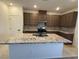 Gorgeous kitchen island with granite counters, stainless appliances and brown cabinetry at 3667 Inspirato Ave, Henderson, NV 89044