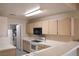 Bright kitchen featuring a smooth top range, microwave, and tile countertops at 3672 Angela Robin St # 202, Las Vegas, NV 89129