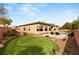 This backyard includes a pool, putting green, brick walls and desert landscaping at 39 Cranberry Cove Ct, Las Vegas, NV 89135