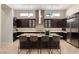 Modern kitchen features dark wood cabinets, stainless steel appliances, and a large center island with seating at 39 Cranberry Cove Ct, Las Vegas, NV 89135