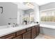 Bright bathroom featuring a double sink, bathtub and glass shower, and wooden floor at 440 Point Sur Ave, Las Vegas, NV 89138