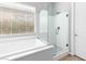 Modern bathroom showcasing glass-enclosed shower and soaking tub with a window at 440 Point Sur Ave, Las Vegas, NV 89138