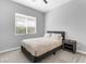 Neutral bedroom features a full bed, side table, and window with blinds at 440 Point Sur Ave, Las Vegas, NV 89138