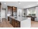 Kitchen with large island and sink, stainless steel appliances, dark wood cabinetry and adjacent dining area at 440 Point Sur Ave, Las Vegas, NV 89138