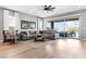 Bright and airy living room with a large sectional, hardwood floors, and sliding glass doors at 440 Point Sur Ave, Las Vegas, NV 89138