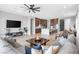Spacious living space with a large sectional sofa, ceiling fan, and open kitchen at 440 Point Sur Ave, Las Vegas, NV 89138