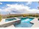 Backyard pool and hot tub combination with lounge seating and surrounding desert landscaping at 440 Point Sur Ave, Las Vegas, NV 89138