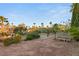 Spacious backyard featuring gravel landscaping, mature trees, and desert foliage under a bright sky at 4775 N Tee Pee Ln, Las Vegas, NV 89129