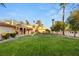 Expansive backyard featuring lush lawn, mature trees, and charming Mediterranean architecture with a spiral staircase at 4775 N Tee Pee Ln, Las Vegas, NV 89129