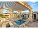 Luxury backyard featuring a pool, spa, covered patio, and lush landscaping perfect for outdoor relaxation at 4775 N Tee Pee Ln, Las Vegas, NV 89129