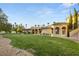 Spacious backyard with a lush green lawn, mature trees, and a beautiful Mediterranean-style home at 4775 N Tee Pee Ln, Las Vegas, NV 89129