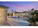 Luxury backyard featuring a pool, spa, lush landscaping, and ambient lighting for evening enjoyment at 4775 N Tee Pee Ln, Las Vegas, NV 89129