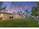 A well-maintained backyard with a large lawn, mature trees, and a charming Mediterranean-style home at 4775 N Tee Pee Ln, Las Vegas, NV 89129