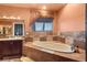 Bathroom features a soaking tub with tile surround, large window, neutral paint, and a dark wood vanity at 4775 N Tee Pee Ln, Las Vegas, NV 89129