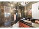 Stylish bathroom boasts stone tile in shower, glass door, sleek vanity, and modern fixtures at 4775 N Tee Pee Ln, Las Vegas, NV 89129