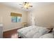 Bright bedroom featuring a ceiling fan, hardwood floors, and a window with blinds at 4775 N Tee Pee Ln, Las Vegas, NV 89129