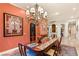 Elegant dining room featuring a large chandelier, rich wood table, and beautiful artwork at 4775 N Tee Pee Ln, Las Vegas, NV 89129