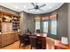 This home office has wood floors, custom built-ins, and a large desk with comfortable chairs at 4775 N Tee Pee Ln, Las Vegas, NV 89129