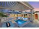 Resort-style backyard featuring a sparkling pool, spa, fire pit, and covered patio for outdoor entertaining at 4775 N Tee Pee Ln, Las Vegas, NV 89129