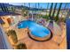 Overhead view of a dazzling pool with unique design elements, fire pits, and mature landscaping at 4775 N Tee Pee Ln, Las Vegas, NV 89129