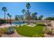 Beautiful backyard oasis with a pool, artificial turf, desert landscaping, and mature trees at 5217 Cold River Ave, Las Vegas, NV 89130