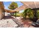 Outdoor oasis with a covered patio, rock landscaping, and lush greenery, perfect for relaxing and entertaining at 5217 Cold River Ave, Las Vegas, NV 89130