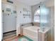 Bright bathroom featuring a soaking tub, walk-in shower, arched window and beach themed decor at 5217 Cold River Ave, Las Vegas, NV 89130