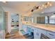 Bright bathroom featuring double sinks, decorative mirror and decor, plus a glass enclosed shower at 5217 Cold River Ave, Las Vegas, NV 89130