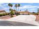 Charming single-story home with a spacious driveway and desert landscaping, complemented by tall palm trees at 5217 Cold River Ave, Las Vegas, NV 89130