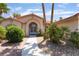 Inviting front entrance with an arched doorway, decorative plants, and a well-maintained walkway at 5217 Cold River Ave, Las Vegas, NV 89130