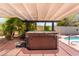 Inviting backyard featuring a relaxing hot tub under a shaded pergola, surrounded by lush tropical landscaping at 5217 Cold River Ave, Las Vegas, NV 89130