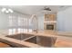 Kitchen island sink and faucet detail with a view of the stone fireplace and windows at 5217 Cold River Ave, Las Vegas, NV 89130