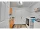 Functional laundry room with washer, dryer, storage cabinets, a hanging rod and a white exterior door at 5217 Cold River Ave, Las Vegas, NV 89130