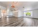 Spacious living room with gray flooring, light walls, ceiling fans, and a large wall mirror at 5217 Cold River Ave, Las Vegas, NV 89130
