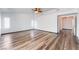 Spacious living room with modern wood flooring, ceiling fan, and bright white walls at 5217 Cold River Ave, Las Vegas, NV 89130
