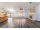Open living room featuring a stone fireplace, light walls, gray flooring, and kitchen access at 5217 Cold River Ave, Las Vegas, NV 89130