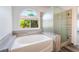 Modern tub featuring wood-look accents, a window view and a clear glass shower at 5217 Cold River Ave, Las Vegas, NV 89130