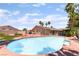 Beautiful backyard pool surrounded by lush greenery, palm trees, and patio space for outdoor relaxation at 5217 Cold River Ave, Las Vegas, NV 89130