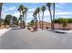 Street view of community entry way with gate surrounded by mature trees and desert landscaping at 5217 Cold River Ave, Las Vegas, NV 89130
