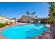 Backyard with an in-ground swimming pool, covered patio, desert landscaping, and mature palm trees at 5217 Cold River Ave, Las Vegas, NV 89130