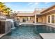 Backyard pool featuring waterfall, stairs to upper patio, and lush landscaping at 540 Regents Gate Dr, Henderson, NV 89012