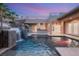 Backyard pool with waterfall feature surrounded by palm trees, lights, and steel railing at 540 Regents Gate Dr, Henderson, NV 89012